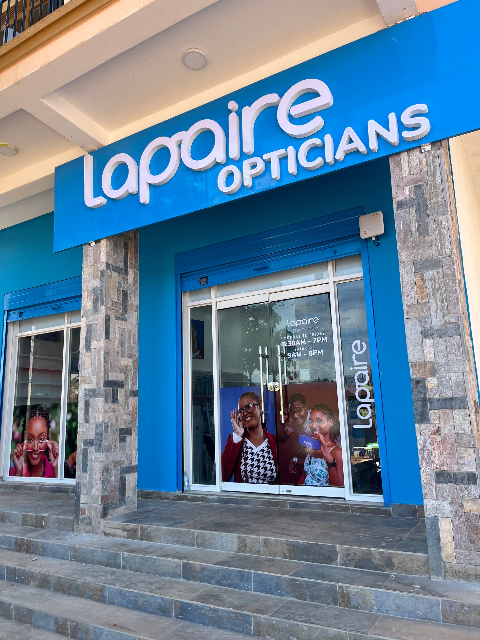 A front view of Lapaire Opticians with a blue and white signage, a glass door, and a visible waiting area.